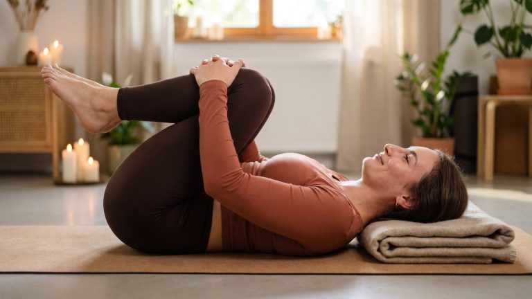 Tanya hugging her knees to her chest to ease lower back pain