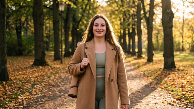 Tanya walking to yoga class through a leafy Golders Green park in autumn